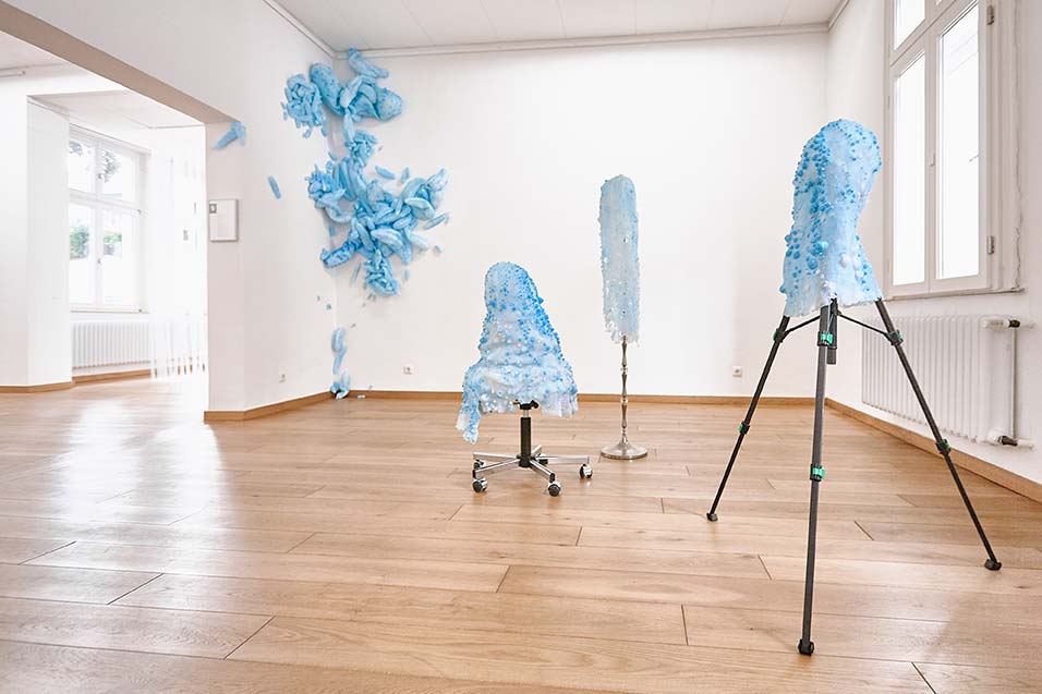 Beyond Control, 2020. Wall installation, silicone, pigments, ca. 330 x 400 x 20 cm | Lampstand, tripod, office chair, silicone and pigments, filler | Art Association Gelsenkirchen | 
Photo by Marco Wittkowski © All rights reserved.