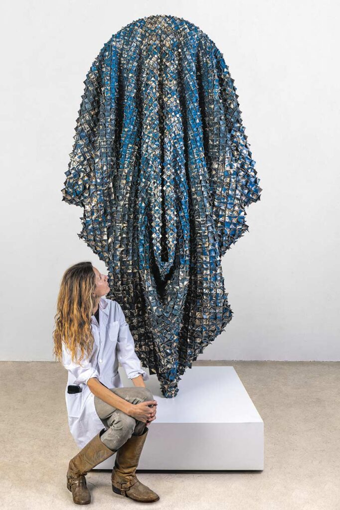 Exhibition view. "CALYPSO" (2024), Catalina reinterprets the legacy of the mythical sea nymph (Nereid) from Greek mythology, whose name means mystery and concealment. Using the embossed leather of book spines taken from a fictional library dedicated to women, the artist creates a woven ritual cloak that redefines the female narratives absent from official history.
The artist deconstructs and reconfigures the book's materiality, transforming it into a ritual object. In this work, the hidden and silenced stories of women are made present in the form of a cloak.
Catalina Swinburn © Selma Feriani Gallery